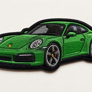 May include: An embroidered patch featuring a bright green sports car with a black border. The design includes detailed silver wheels, a yellow and black emblem on the hood and wheel centers, and black window accents, capturing the sleek silhouette.