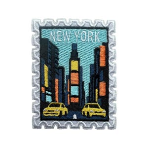 Op de afbeelding: Geborduurde patch met een gestileerde skyline van New York. Het ontwerp toont hoge gebouwen, gele taxi's en de tekst "NEW YORK" bovenaan. De patch heeft een witte, geschulpte rand, die lijkt op een postzegel.