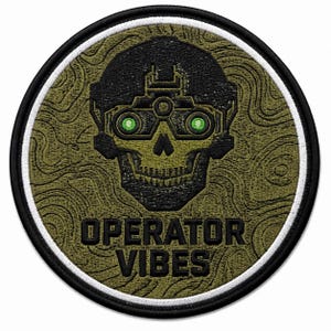 May include: A circular embroidered patch featuring a black skull wearing night vision goggles with bright green lenses. The background is an olive green topographic map pattern. The text OPERATOR VIBES is stitched in black below the skull.