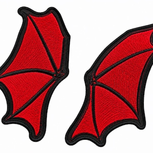May include: Two embroidered patches shaped like bat wings, featuring vibrant red fabric with black stitched detailing and a thick black border. The wings are depicted in a symmetrical layout, showcasing the distinct pointed structure of the wing tips.