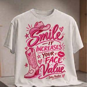 Könnte beinhalten: Ein weißes kurzärmeliges T-Shirt mit einem rosa Grafikdesign aus einem Cowboyhut, einem Cowboystiefel mit Smiley-Gesicht, Lippen und Herzen. Der Text lautet: Smile - IT INCREASES YOUR FACE VALUE. - Dolly Parton.