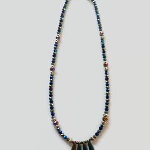May include: A blue and iridescent crystal beaded necklace with a gold clasp and a pendant of three dark green iridescent teardrop-shaped stones.