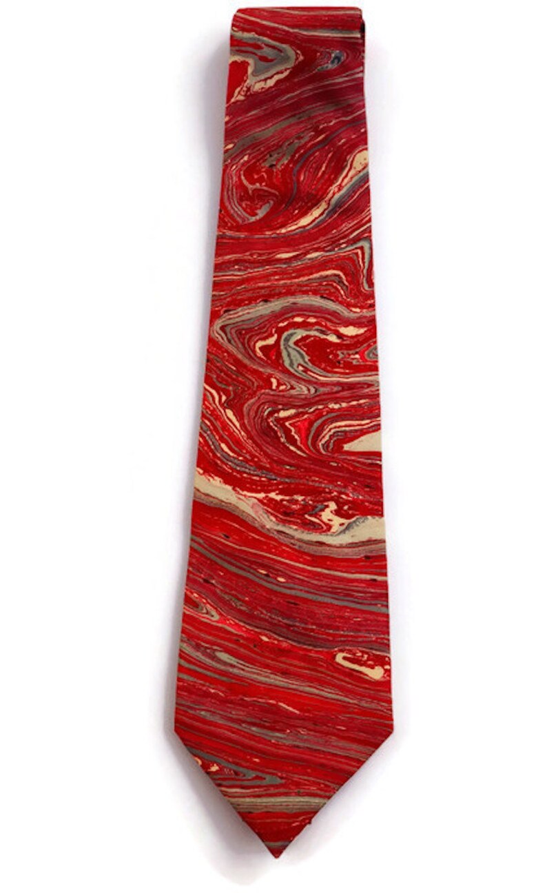 May include: A red tie with a marbled pattern in shades of red, cream, and gray.