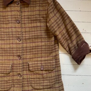May include: A brown and burgundy plaid jacket with a corduroy collar and two patch pockets. The jacket has a button closure.