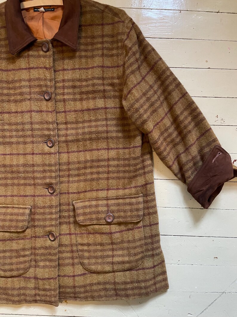 May include: A brown and burgundy plaid jacket with a corduroy collar and two patch pockets. The jacket has a button closure.