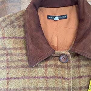 May include: A brown and green plaid jacket with a brown suede collar. The jacket has a label that says "Mark Shale".