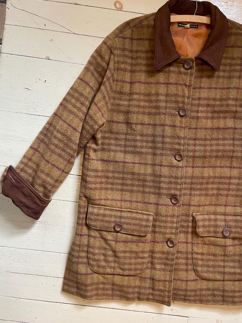 May include: A brown and burgundy plaid jacket with a corduroy collar. The jacket has a button closure and two flap pockets.