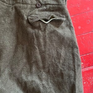 Peut inclure: Un pantalon en laine marron avec un seul bouton &agrave; la taille et une poche arri&egrave;re.