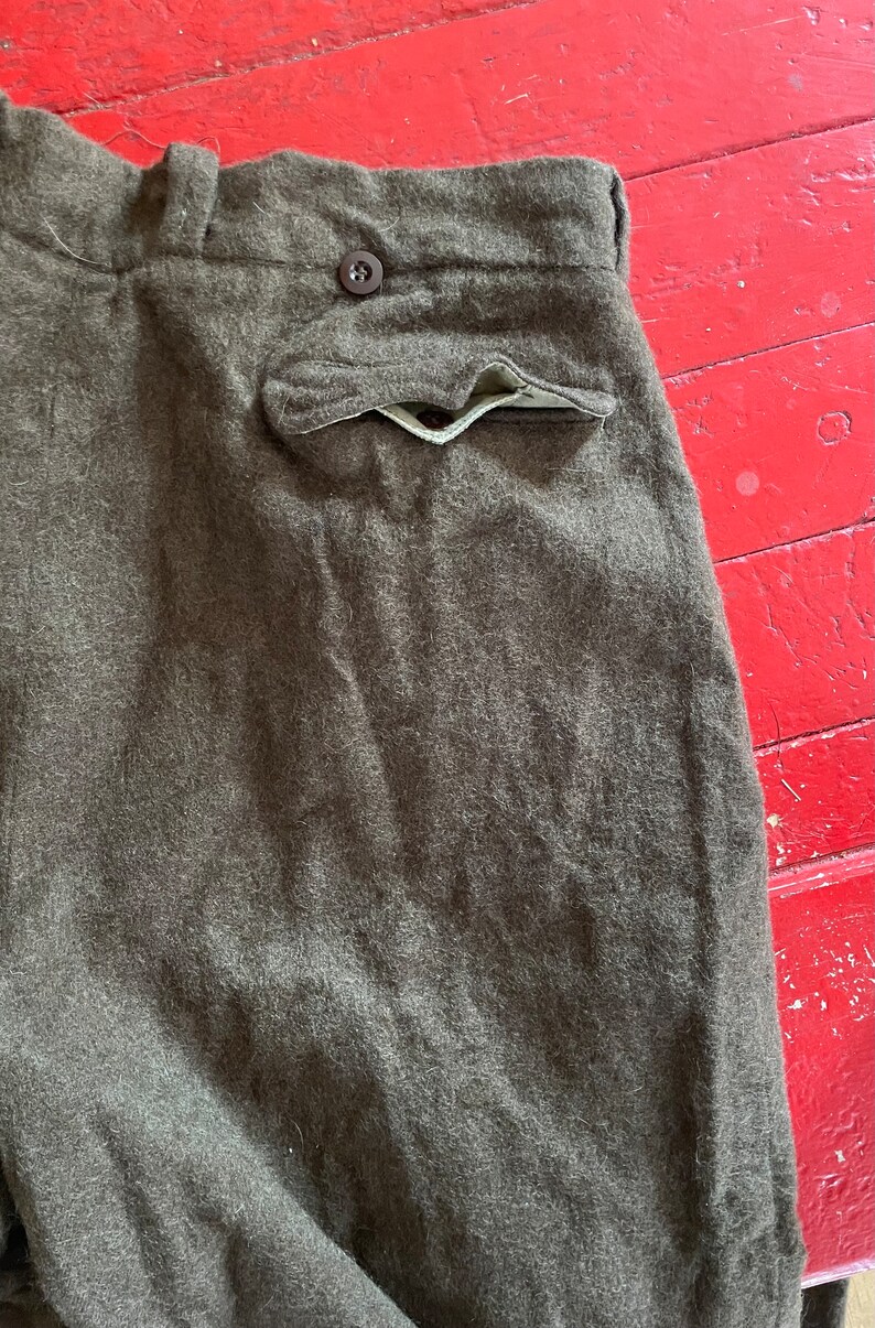 Peut inclure: Un pantalon en laine marron avec un seul bouton &agrave; la taille et une poche arri&egrave;re.
