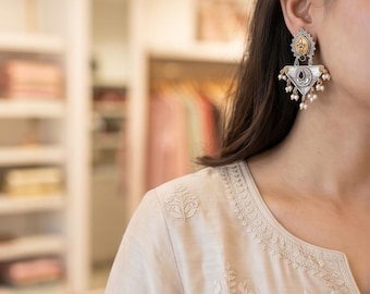 Pendientes Jhumka de dos tonos en plata oxidada y oro, con colgantes de perlas y piedras negras de estilo tribal fusión.