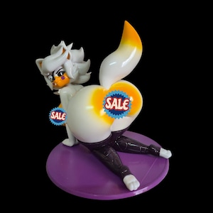 May include: A white and orange fox-like figurine in a kneeling pose, with a purple base. The figurine has a stylized design, with a large tail and a "SALE" sticker on the rear. The figure is wearing black pants.