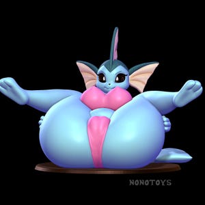 May include: A light blue creature figurine with large ears, a fin on its head, and dark eyes. It wears a pink top and a pink loincloth. The figure has a rounded, oversized body and is positioned on a brown circular base with the text NONOTOYS.