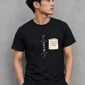 May include: Black crew neck t-shirt with Japanese calligraphy and a sticky note that says "- Your name in Japanese writing". The shirt is worn by a person.