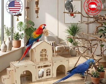 May include: A light-colored wooden bird playhouse with multiple arched openings, a central tower, and stairs. A red, yellow, and blue macaw sits on the roof, a white cockatoo is inside, a gray parrot is on a branch, and a blue macaw stands nearby.