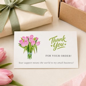 May include: A rectangular white thank you card featuring a watercolor illustration of a pink tulip bouquet tied with a light blue ribbon. The card displays the green text Thank You, the black text FOR YOUR ORDER!, and a small business message.