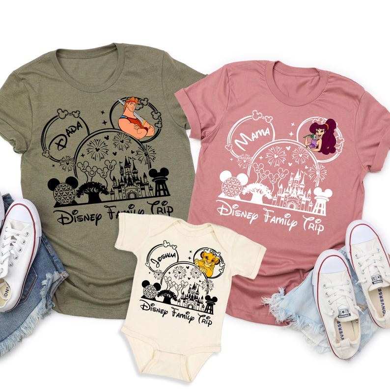 Puede incluir: Tres camisetas con tem&aacute;tica de Disney y un body para beb&eacute;. Las camisetas son de color verde oliva y rosa empolvado, y el body es de color crema. Cada art&iacute;culo presenta un dise&ntilde;o de oreja de Mickey Mouse con personajes de Disney, fuegos artificiales y el texto "Disney Family Trip".