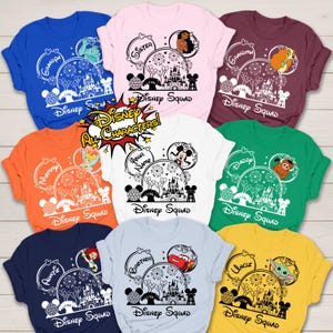 Puede incluir: Una colecci&oacute;n de camisetas Disney Squad coloridas. Cada camiseta presenta un dise&ntilde;o &uacute;nico con personajes de Disney, fuegos artificiales y un castillo. Los textos incluyen "Grandpa", "Sister", "Mommy", "Your Name", "Daddy", "Auntie", "Brother" y "Uncle".