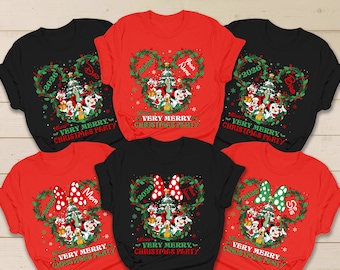 May include: A collection of six short-sleeved t-shirts in red and black, each featuring a graphic of a Christmas tree surrounded by a wreath, Disney characters, the year 2026, and the text "VERY MERRY CHRISTMAS PARTY" with personalized labels.