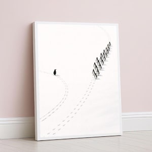 May include: A framed art print depicting penguins on a white backdrop. One penguin is shown walking away from a group, leaving footprints. The artwork is displayed against a pale pink wall, creating a minimalist aesthetic.