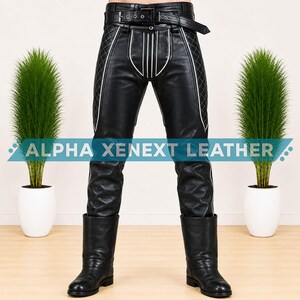 May include: Black leather pants featuring a quilted diamond pattern on the outer thighs, white piping accents, and a buckled belt at the waist. The pants include the text ALPHA XENEXT LEATHER across the front and are paired with black leather boots.