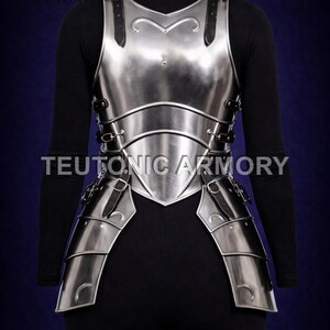 May include: A polished steel breastplate and backplate armour with leather straps and buckles. The armour is designed to cover the torso and is displayed on a mannequin. The Teutonic Armory logo is visible.