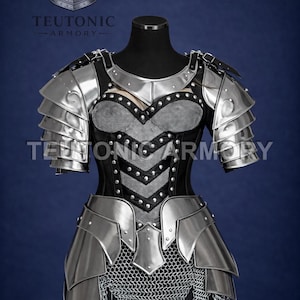May include: A silver and black medieval armor set displayed on a mannequin. The armor features layered metal plates, a studded chest piece, and chainmail. The text "TEUTONIC ARMORY" is visible. The overall design suggests a historical or fantasy theme.