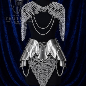 May include: A silver chainmail shoulder piece with hanging chains and a matching metal plate skirt featuring layered plates over a chainmail base. The set includes a logo with the text TEUTONIC ARMORY visible on the upper left side of the display.