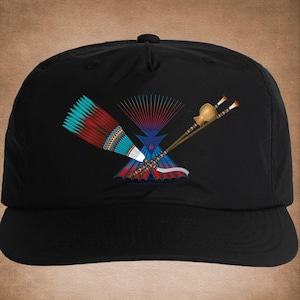 May include: Black baseball cap with an embroidered design of a Native American headdress, feathers, and a pipe. The design is in shades of blue, red, and green. The text "Thunder Puppy Art" is at the bottom of the image.