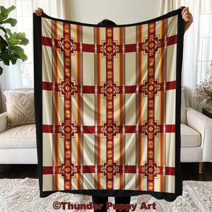 Peut inclure: Une grande couverture rectangulaire avec un motif d'inspiration amérindienne. La couverture présente un fond crème avec des rayures verticales dans les tons de rouge, jaune et marron. Le motif comprend des motifs géométriques rouges et crème. La couverture a une bordure noire.