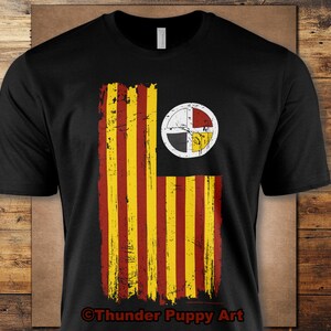 May include: Black t-shirt featuring a distressed design of a flag with vertical red and yellow stripes and a circular emblem. The emblem is white with a cross design and red, black, and yellow sections. The text "Thunder Puppy Art" is at the bottom.