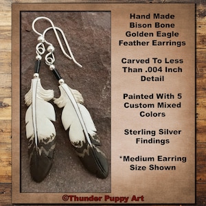 May include: Hand-carved golden eagle feather earrings made from bison bone. The earrings are painted with 5 custom mixed colours and feature sterling silver findings. The image shows the medium size earrings.