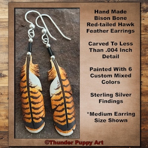 May include: A pair of hand-carved bison bone red-tailed hawk feather earrings. The earrings are painted with six custom mixed colors and feature sterling silver findings. The earrings are shown in a medium size.