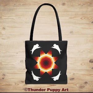 May include: Black tote bag featuring a central eight-pointed star design in shades of red, orange, and yellow. Four white bison silhouettes surround the star. The bag has black handles and the text "Thunder Puppy Art" at the bottom.