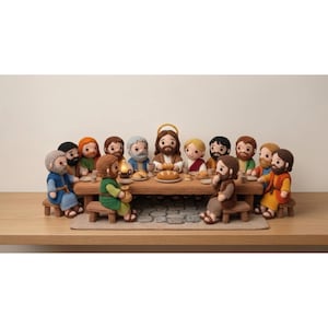 May include: A crocheted depiction of the Last Supper, featuring twelve figures seated around a wooden table. The figures have various skin tones, hair colors, and clothing. A loaf of bread and a lit candle are on the table. The scene is set on a wooden surface.