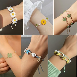 以下が含まれることがあります： さまざまなデザインの手作りかぎ針編みブレスレットのコレクション。デイジー、ヒマワリ、サボテン、クローバー、貝殻、ヒトデ、タツノオトシゴ、ミツバチのモチーフが特徴です。各ブレスレットは、カラフルな糸と繊細なディテールで手作りされており、気まぐれで芸術的なスタイルを示しています。