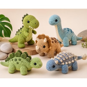 May include: A collection of four crocheted dinosaur toys. The group includes a green T-Rex, a light blue long-necked dinosaur, a tan triceratops with a frill, a green stegosaurus with back plates, and a blue ankylosaurus with textured back bumps.