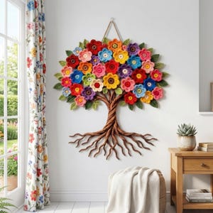 Può includere: Un'applique da parete fatta a mano raffigurante un albero con un tronco e radici marroni ritorti e una vivace corona di fiori all'uncinetto colorati in rosso, giallo, blu e viola. L'opera è sospesa da una corda naturale.