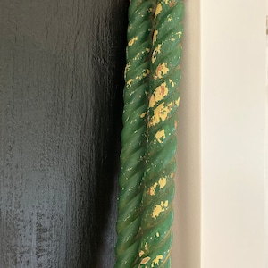 May include: Two green rope-like wooden spindles with a distressed, weathered finish. The spindles are twisted together and have a worn, aged look.