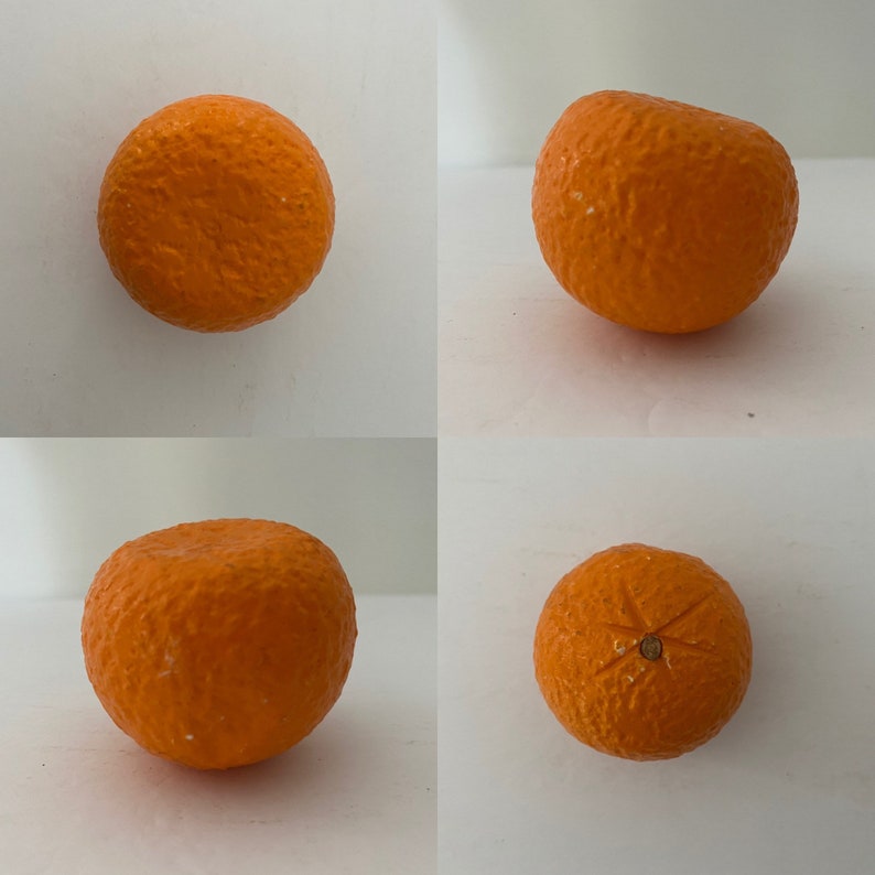 May include: Four whole oranges, each with a slightly different texture and color, are arranged on a white background. The oranges are round and have a slightly bumpy surface.