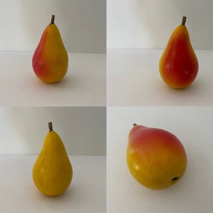 May include: Four yellow pears with red blush. The pears are arranged in a grid pattern on a white background.