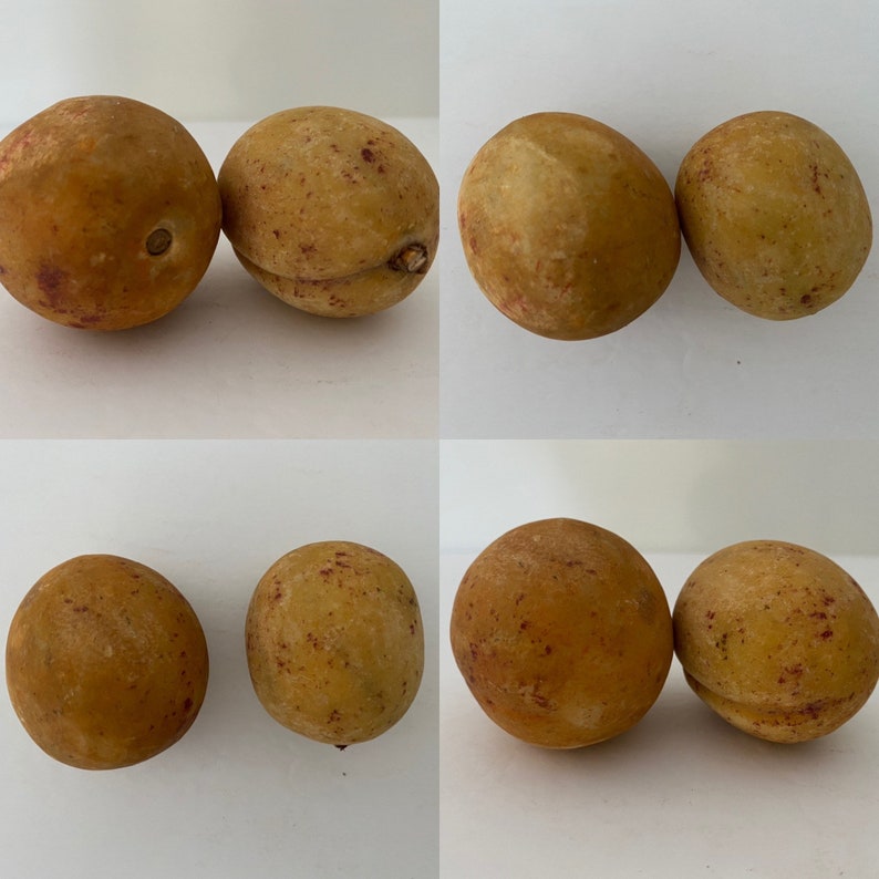 May include: Six brown, slightly wrinkled fruits with a reddish hue. The fruits are arranged in two groups of three.