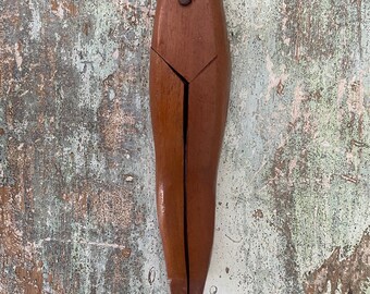 May include: A wooden shoe stretcher with a brown finish. The stretcher is open and has a pointed end.