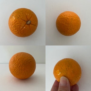 May include: Four whole oranges, with a rough, textured skin, are shown on a white background. The oranges are a vibrant orange color.