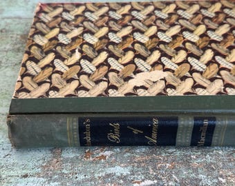 May include: A vintage hardcover book titled "Audubon's Birds of America" with a green cover and a pattern of brown feathers on the spine. The book is published by Macmillan.