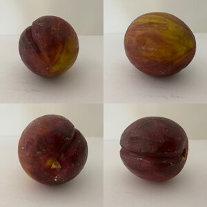 May include: Four ripe figs, two with a deep purple hue and two with a yellow-green skin, are arranged in a grid pattern on a white surface.