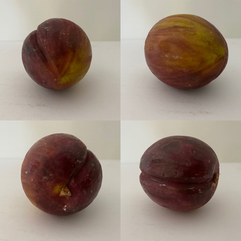 May include: Four ripe figs, two with a deep purple hue and two with a yellow-green skin, are arranged in a grid pattern on a white surface.
