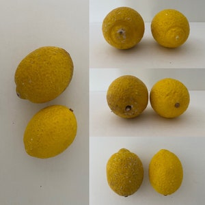 May include: A collection of nine yellow lemons, some with a slight green tint, arranged in three rows. The lemons have a textured surface and are slightly misshapen.