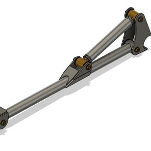 Puede incluir: Un componente de suspensión metálico plateado con una base rectangular y brazos de soporte angulados. El diseño incluye casquillos y sujetadores dorados, lo que sugiere una pieza mecánica o automotriz.