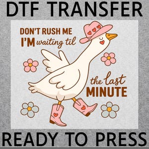 May include: DTF transfer design featuring a cartoon goose wearing a pink cowboy hat and boots, with the text "Don't rush me I'm waiting til the last minute." The design includes flowers and is ready to press.