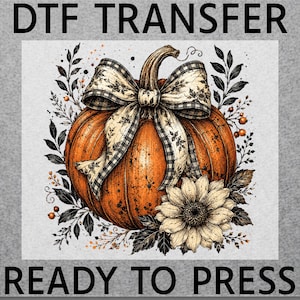 May include: A DTF TRANSFER READY TO PRESS graphic featuring a large orange pumpkin adorned with a black and white checkered bow, surrounded by black ink-style botanical illustrations and a single light-colored sunflower at the base.